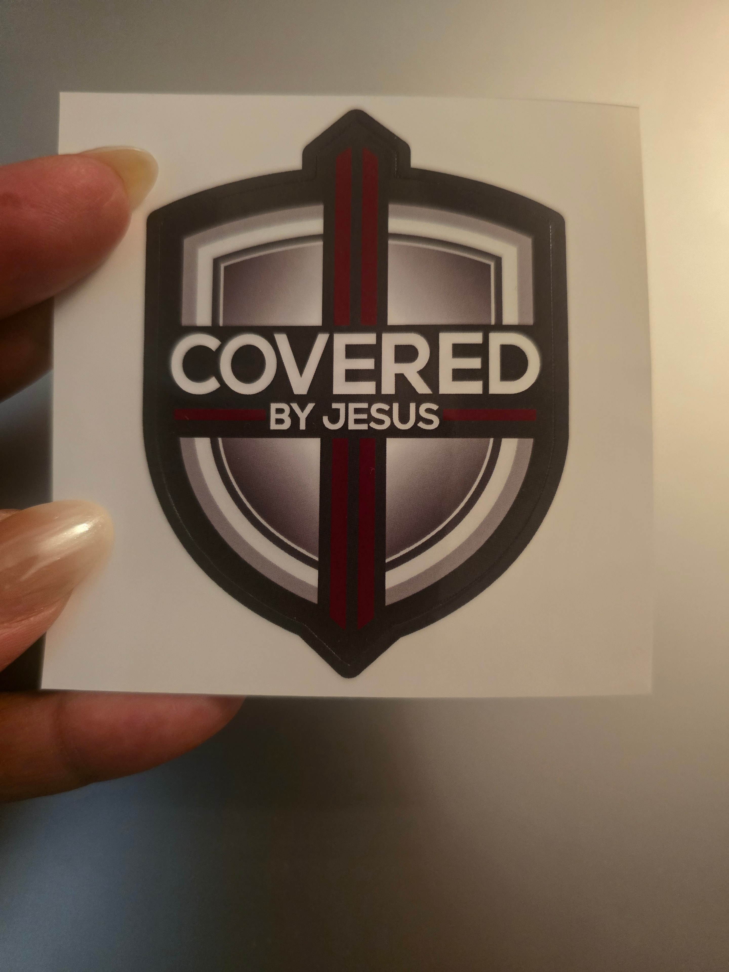 Covered By Jesus security sticker on a window